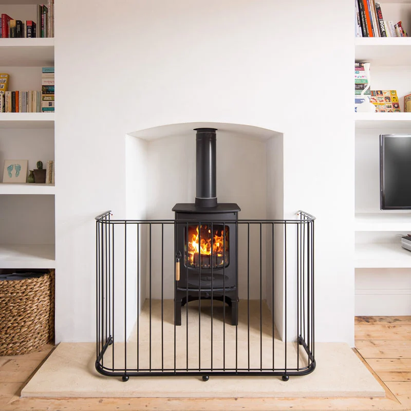 contemporary-fire-guard-01 A contemporary handmade fireguard in black painted steel bars front of a log burner stove