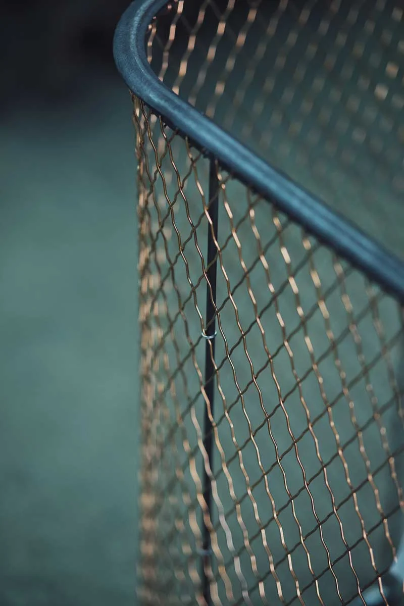 A close-up of a traditional crimped wire fireguard during production