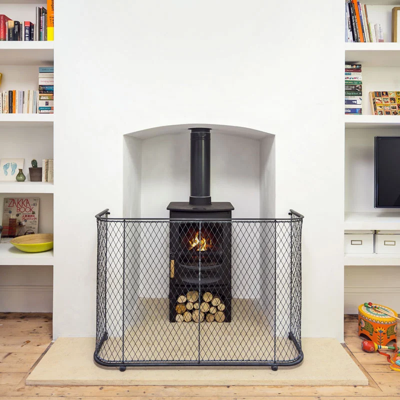 traditional-fire-guard-01 A traditional handmade fireguard in black painted woven steel mesh in front of a log burner stove