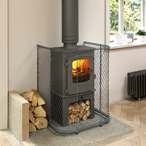 A bespoke made wire work fireguard place around a wood burning stove.