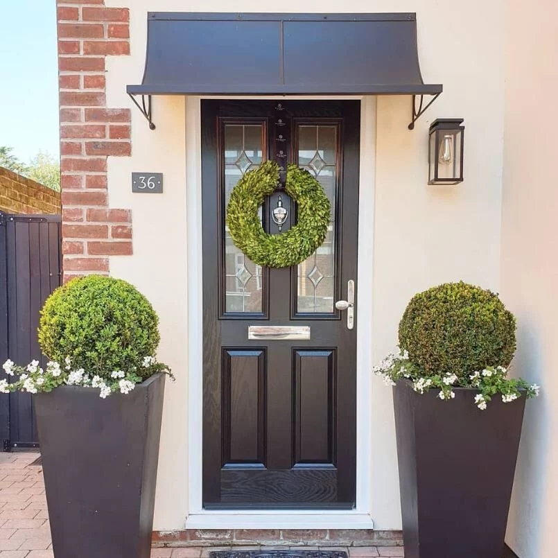 A black zinc metal canopy above the front door of a house.