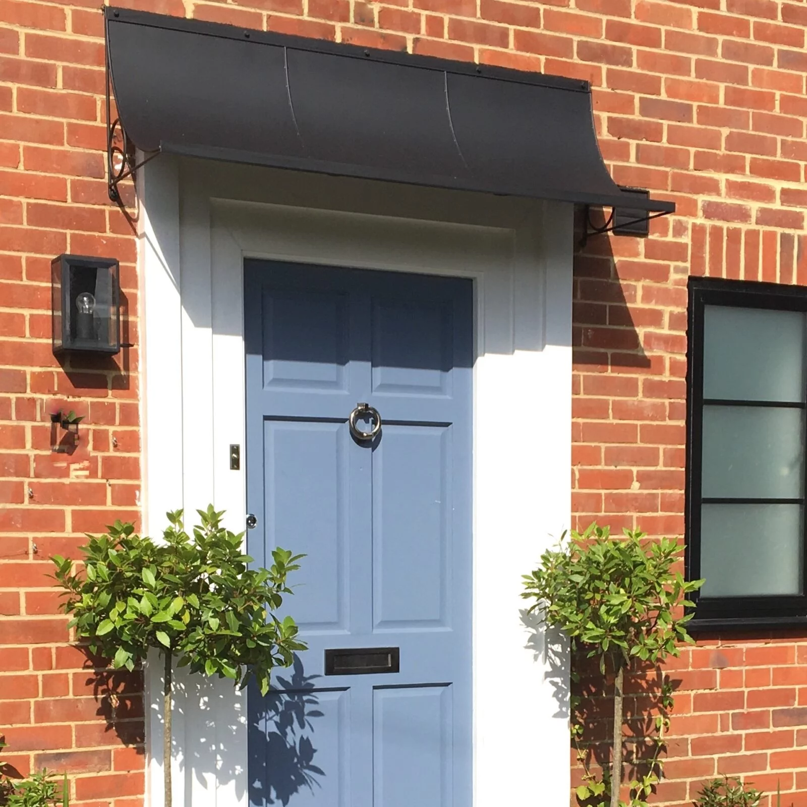 a black painted door canopy above the front door of a house