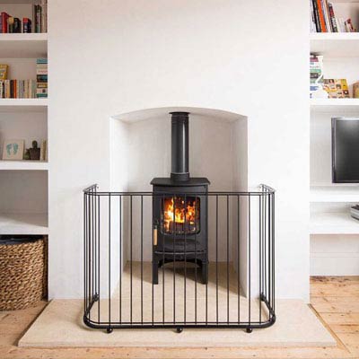 Log burner with a contemporary style hand made metal fire guard around