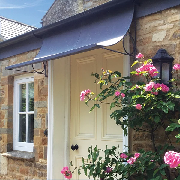 Aged zinc galvanized short canopy over small cottage front door