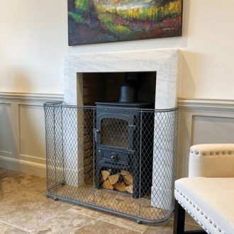 Luxury woven mesh traditional fireguard for woodburning stove around marble fireplace