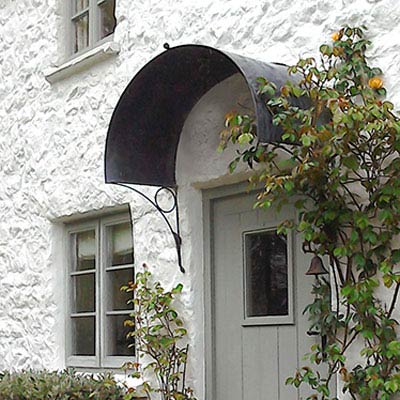Front door with arched galvanized zinc metal door canopy