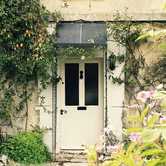 a rustic front door with galvanized metal porch above