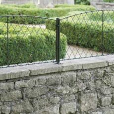 a low garden wall capped with wall top trellis panels in black wire with metal supporting posts