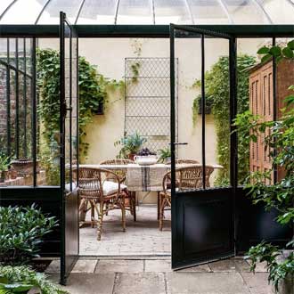 A wire all trellis shown inside a garden conservatory.
